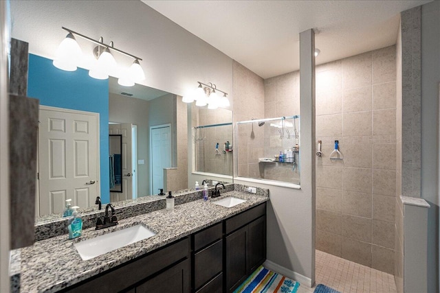 bathroom featuring tiled shower and vanity