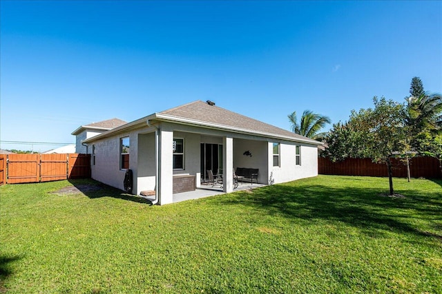 rear view of house featuring a yard and a patio