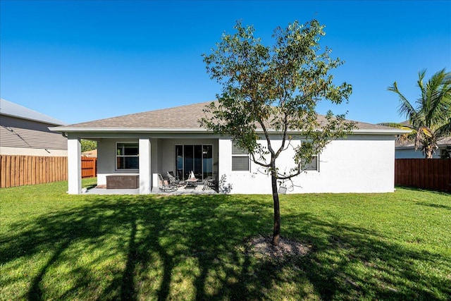 back of property with a yard and a patio