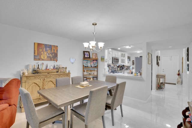 dining space featuring a textured ceiling and a notable chandelier