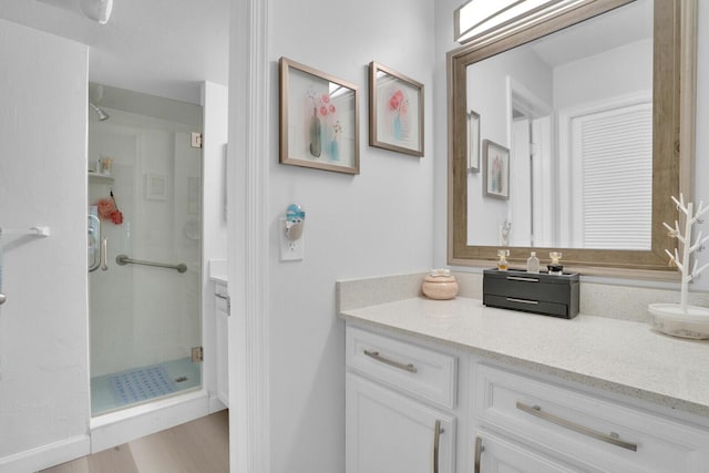 full bathroom with a shower stall, vanity, and wood finished floors