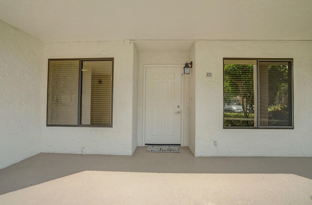 entrance to property featuring stucco siding