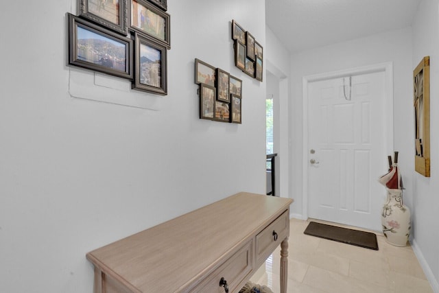 interior space with baseboards and light tile patterned floors