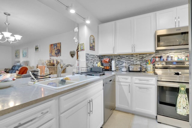 kitchen featuring light tile patterned floors, backsplash, appliances with stainless steel finishes, white cabinets, and a sink