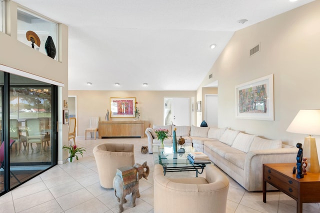 living area featuring high vaulted ceiling, light tile patterned flooring, and visible vents