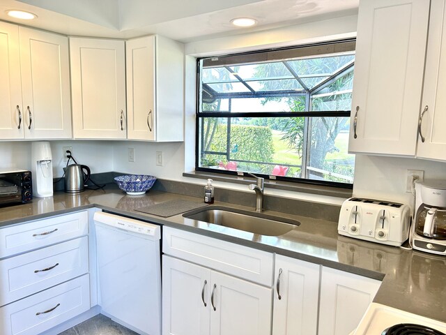 kitchen with a sink, a wealth of natural light, white cabinetry, and dishwasher