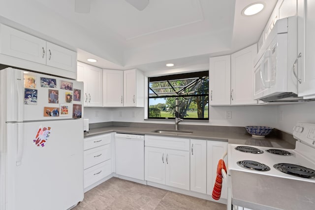 kitchen featuring white appliances, recessed lighting, a sink, and white cabinets