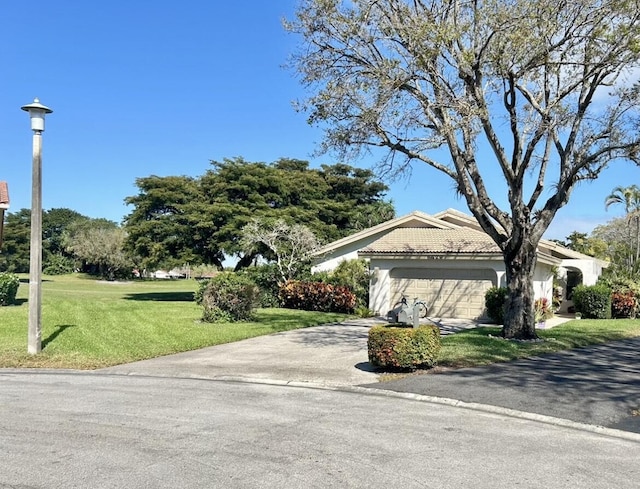 single story home with a tile roof, stucco siding, a garage, driveway, and a front lawn