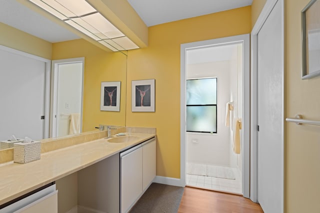 bathroom featuring vanity, baseboards, and wood finished floors