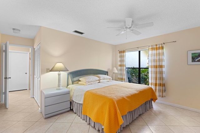 bedroom with light tile patterned floors, ceiling fan, visible vents, and a textured ceiling