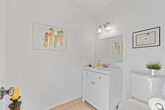 half bath featuring toilet, tile patterned flooring, and vanity