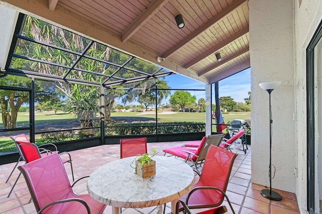 view of patio with glass enclosure and view of golf course