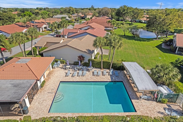 pool with a lawn, a water view, and a residential view