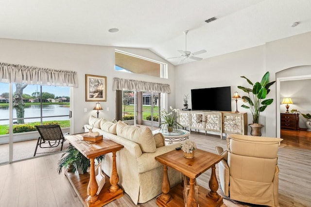 living area featuring visible vents, wood finished floors, a ceiling fan, and plenty of natural light