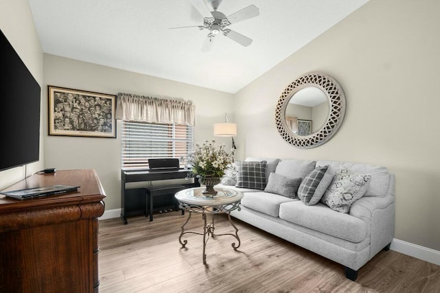 living area with a ceiling fan, wood finished floors, lofted ceiling, and baseboards