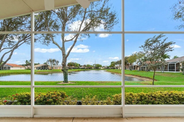 unfurnished sunroom with a water view and a residential view