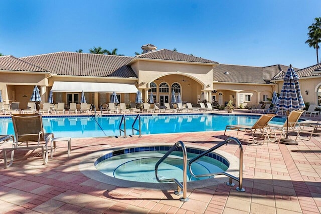 community pool with a patio and a hot tub