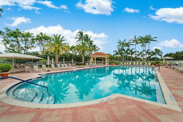 community pool with a patio, a gazebo, and fence