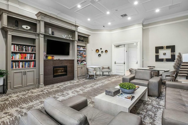 living area with crown molding, visible vents, baseboards, a glass covered fireplace, and recessed lighting
