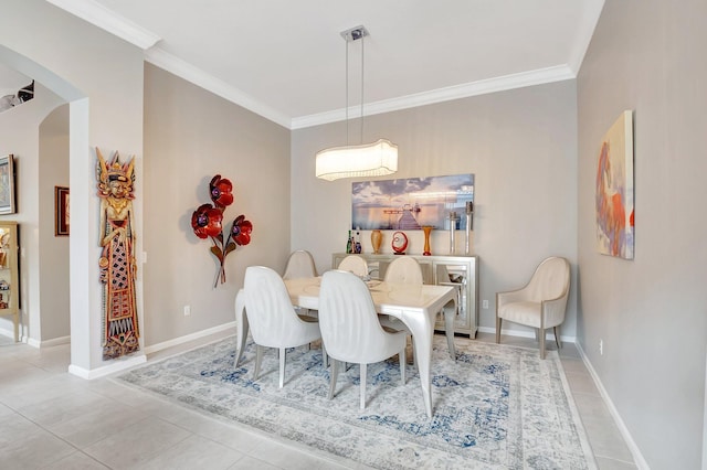 dining space featuring light tile patterned floors, baseboards, and crown molding