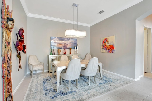 dining room with light tile patterned floors, arched walkways, visible vents, baseboards, and ornamental molding