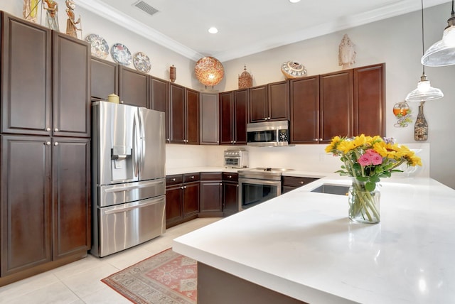 kitchen featuring appliances with stainless steel finishes, light countertops, and pendant lighting