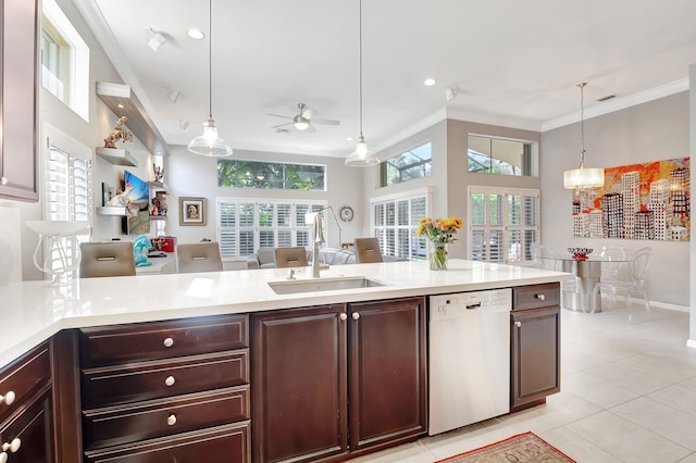 kitchen with pendant lighting, white dishwasher, a sink, light countertops, and crown molding