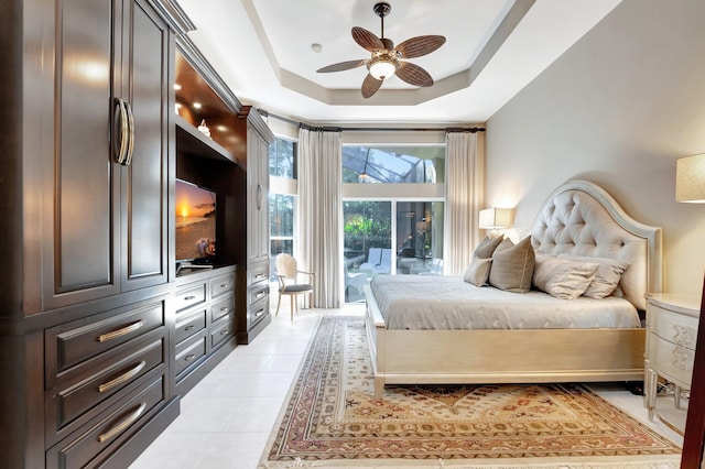 bedroom featuring light tile patterned floors, access to outside, a tray ceiling, and ceiling fan