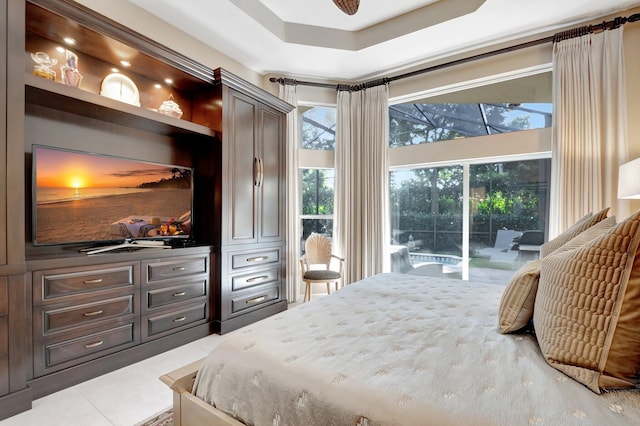 bedroom with access to exterior, light tile patterned floors, and a raised ceiling