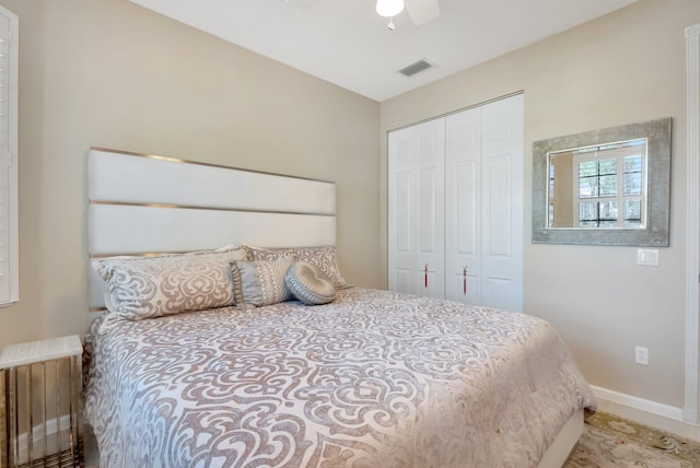 bedroom with baseboards, visible vents, ceiling fan, and a closet