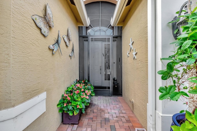 doorway to property featuring stucco siding