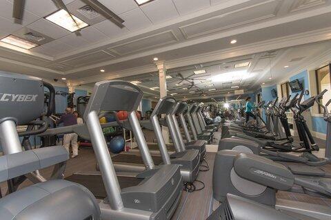 gym with ornamental molding and a raised ceiling