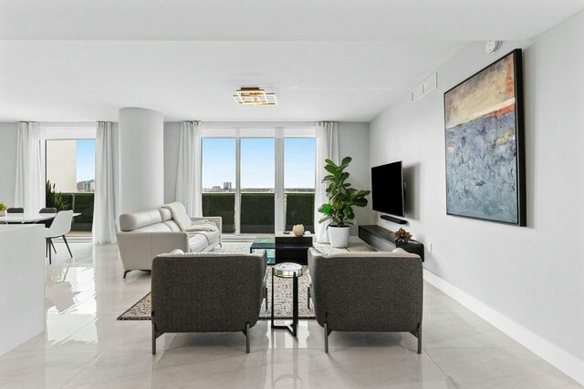 1180 N Federal Hwy Unit 1409, Fort Lauderdale, FL 33304 - living area featuring visible vents, a healthy amount of sunlight, and baseboards