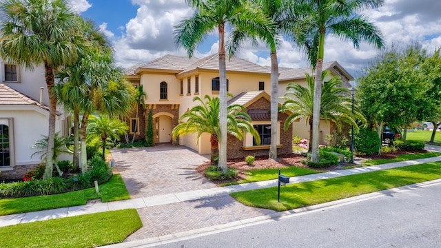 mediterranean / spanish-style house featuring a front yard and a garage