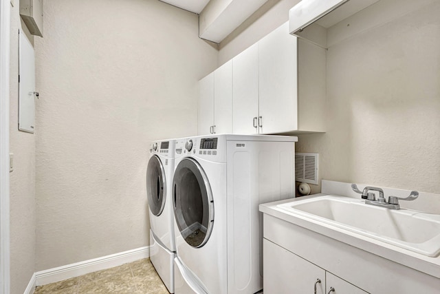 laundry area with light tile patterned flooring, washing machine and clothes dryer, sink, and cabinets