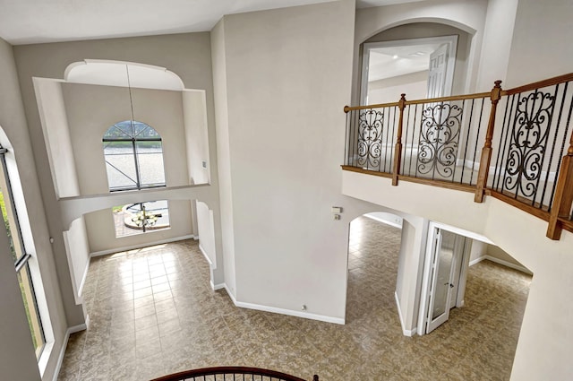 entryway featuring a towering ceiling and an inviting chandelier