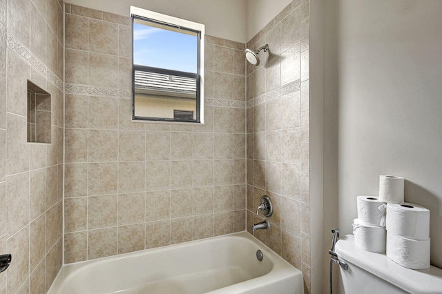 bathroom with toilet and tiled shower / bath combo