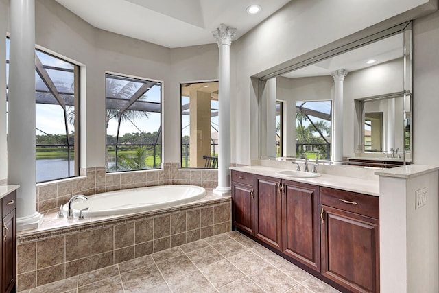 bathroom with vanity, a water view, tile patterned flooring, tiled bath, and ornate columns