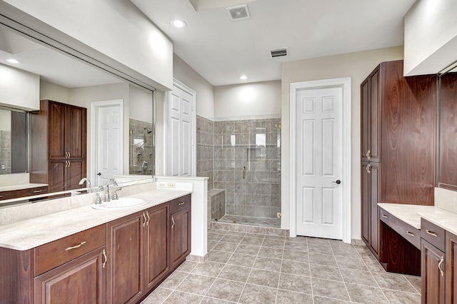 bathroom with tile patterned floors, vanity, and walk in shower