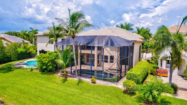 back of house with a yard, a patio, a lanai, and a swimming pool with hot tub