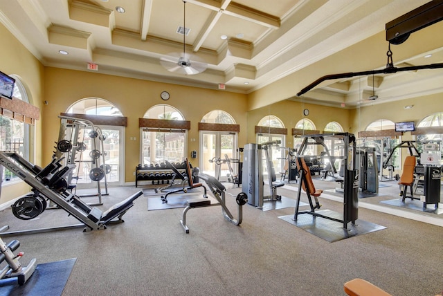 workout area featuring coffered ceiling, ornamental molding, a towering ceiling, and ceiling fan