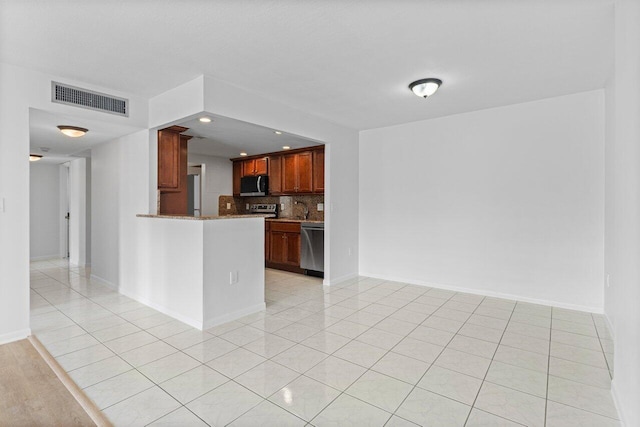 kitchen featuring light tile patterned floors, tasteful backsplash, visible vents, a peninsula, and stainless steel appliances