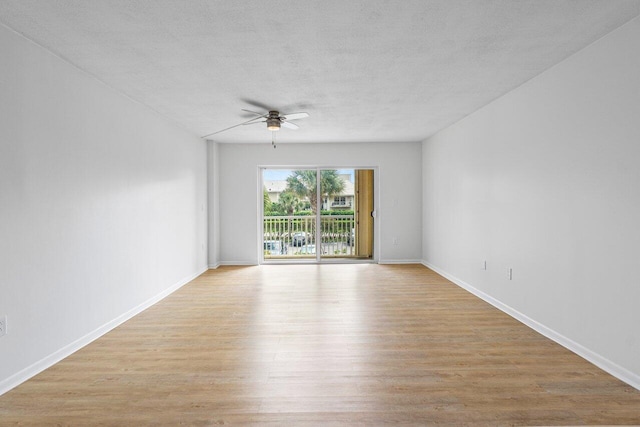 spare room featuring ceiling fan, a textured ceiling, light wood-type flooring, and baseboards