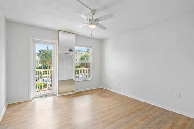 unfurnished room with baseboards, a textured ceiling, a ceiling fan, and light wood-style floors