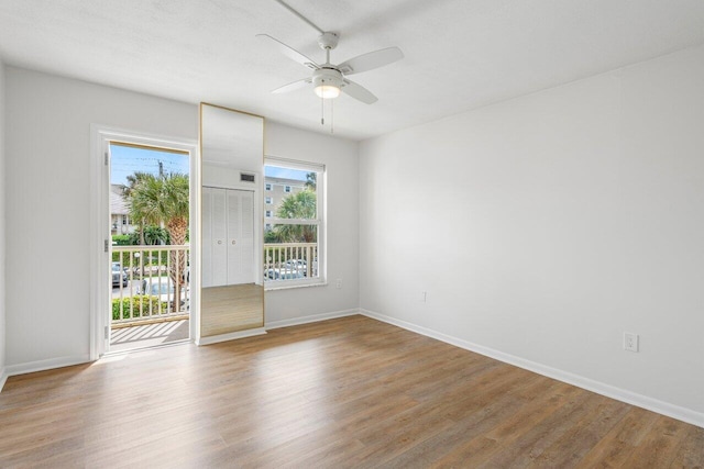 empty room featuring baseboards, light wood-style flooring, and a ceiling fan