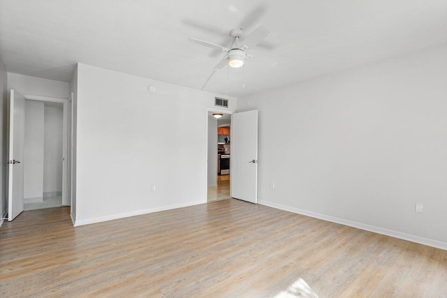 empty room with visible vents, ceiling fan, light wood-style flooring, and baseboards