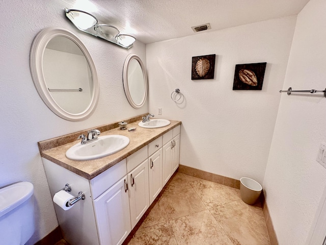 bathroom featuring visible vents, a sink, a textured ceiling, and toilet