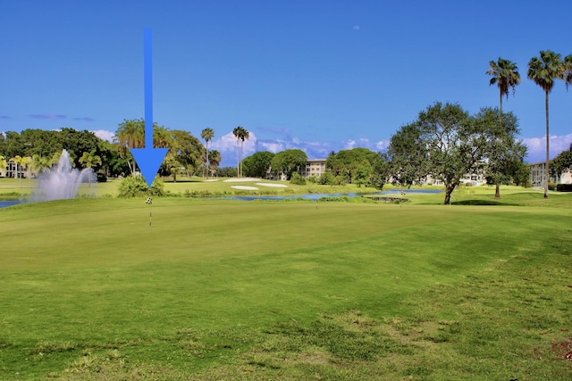 view of community featuring view of golf course, a yard, and a water view