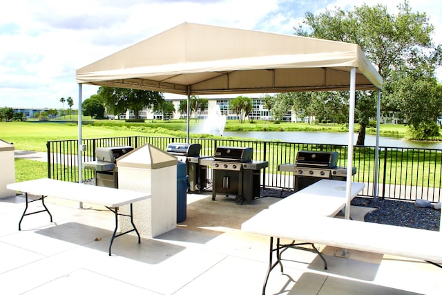 view of patio / terrace featuring a gazebo, grilling area, and a water view