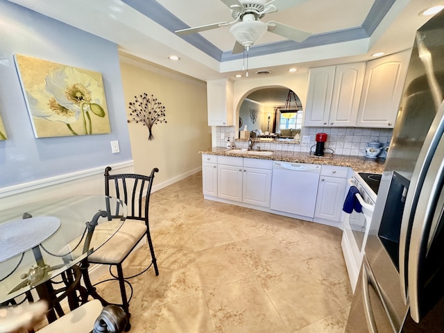 kitchen featuring white appliances, a sink, white cabinetry, tasteful backsplash, and a raised ceiling